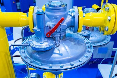 Фотография изображает газовый регулятора давления. Изображение иллюстрирует процессы в топливной промышленности, подчеркивая важность безопасности и эффективности в работе с газовым оборудованием. Может быть использовано в рекламе оборудования для газовой промышленности, а также в учебных материалах по работе с регуляторами давления.